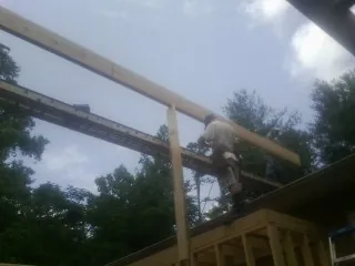 Carpenter setting a ridge beam over a new addition frame — Ice Dam Removal by Roofing Brothers in Timber