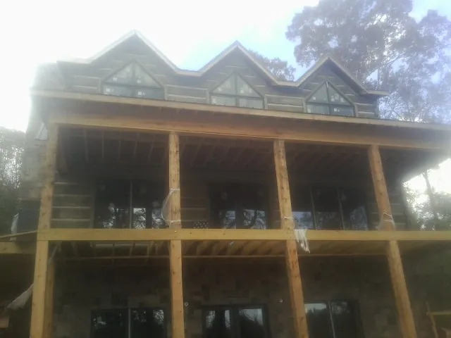 Dormers and porch framing on a large log home under construction in Timber