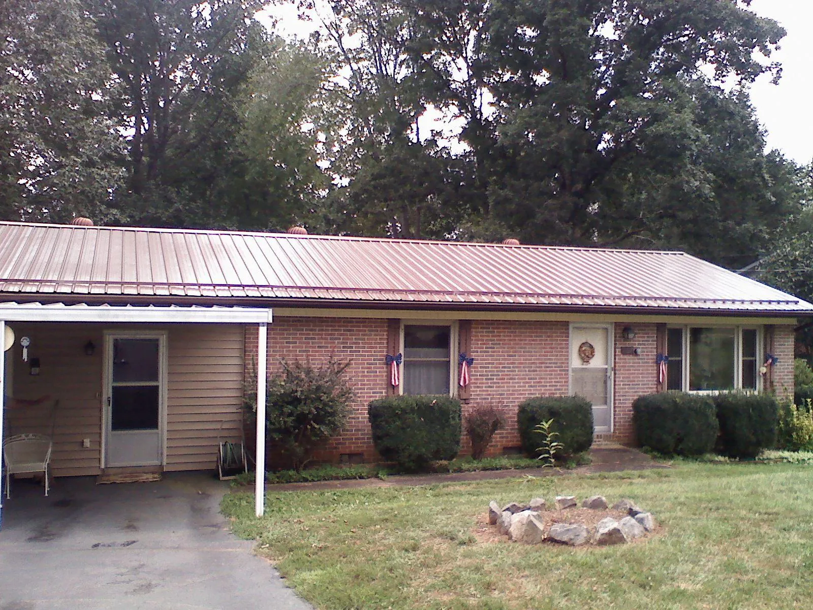 Bronze metal roof and carport on a brick ranch home — Roof Repair work by our crew in Timber